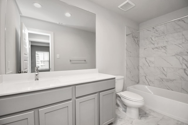 full bathroom featuring vanity, tiled shower / bath combo, and toilet