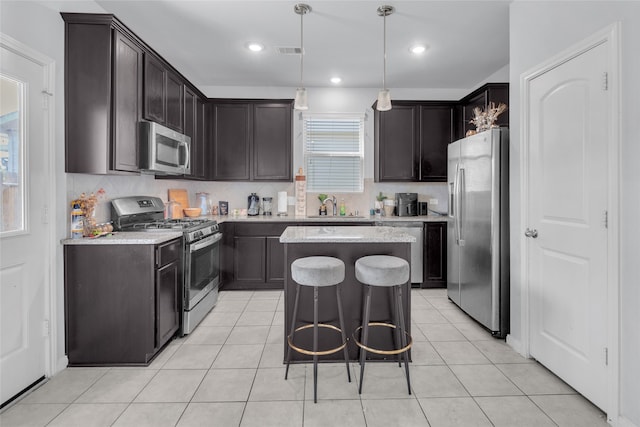 kitchen featuring a kitchen island, dark brown cabinets, backsplash, stainless steel appliances, and pendant lighting