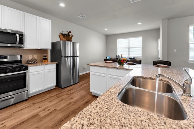 kitchen featuring white cabinets, light stone countertops, sink, and stainless steel appliances