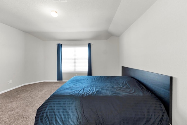 bedroom featuring lofted ceiling and carpet