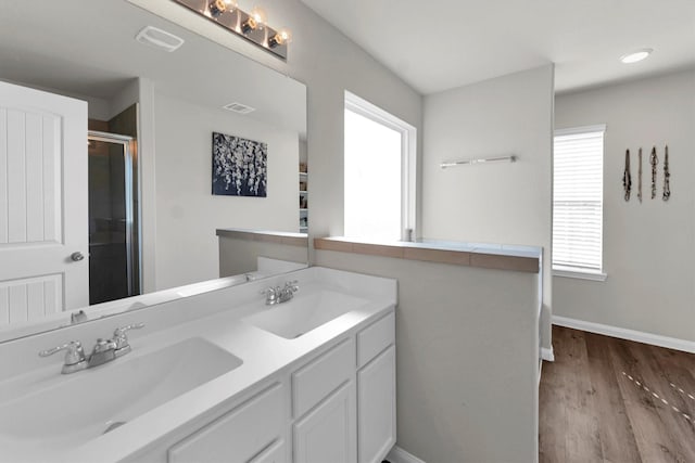 bathroom featuring walk in shower, vanity, and wood-type flooring