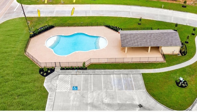 view of swimming pool with a lawn