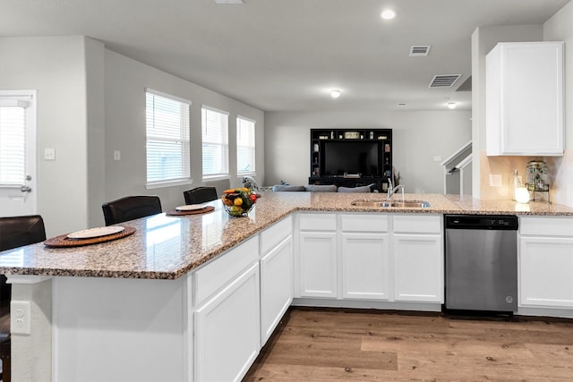 kitchen featuring white cabinetry, stainless steel dishwasher, and kitchen peninsula