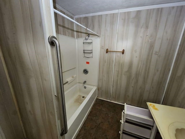 bathroom featuring vanity, wooden walls, and washtub / shower combination