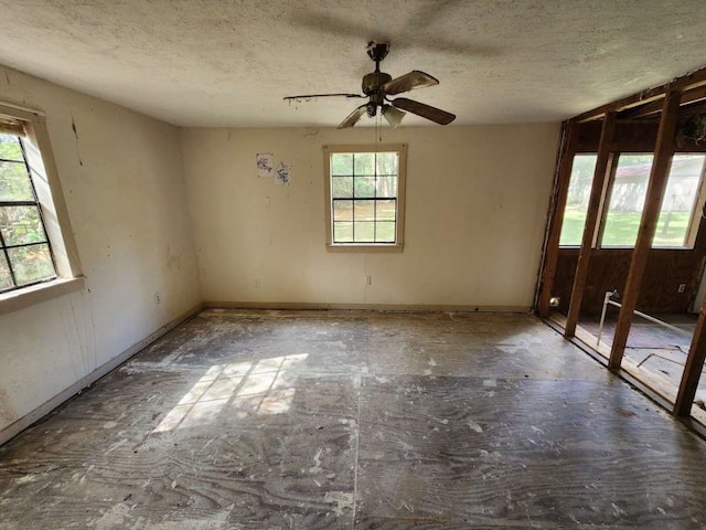 empty room featuring ceiling fan and a textured ceiling