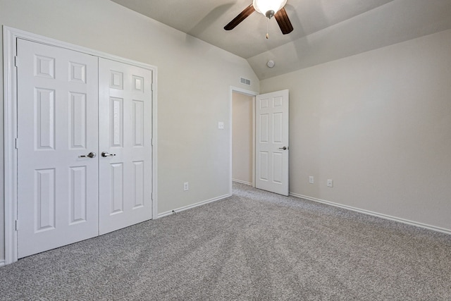 unfurnished bedroom featuring a closet, carpet floors, ceiling fan, and vaulted ceiling