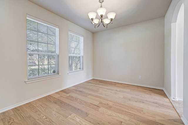 unfurnished room featuring light hardwood / wood-style floors and a notable chandelier