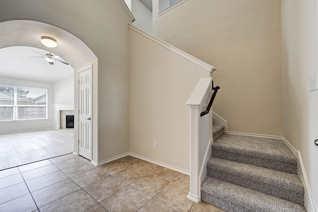 staircase with ceiling fan and tile patterned flooring