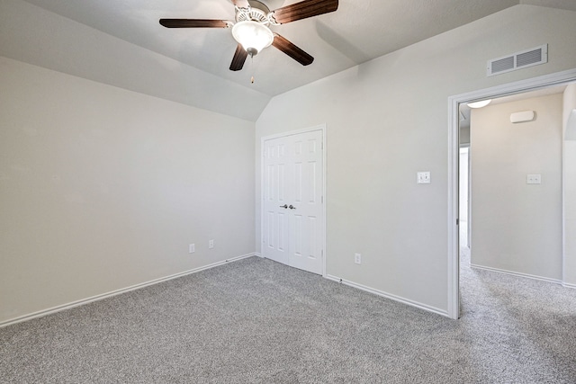 empty room with ceiling fan, carpet, and vaulted ceiling