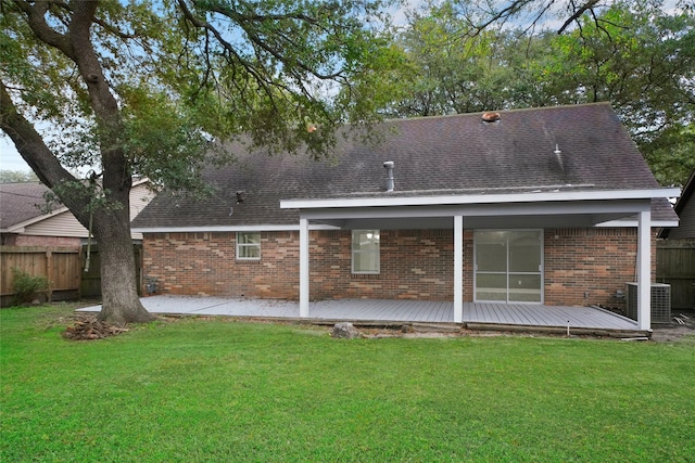 rear view of house featuring central air condition unit, a wooden deck, and a lawn