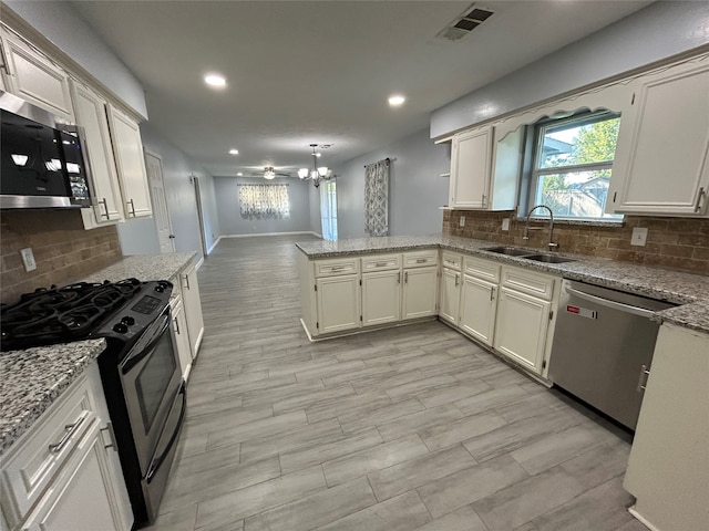 kitchen featuring kitchen peninsula, decorative backsplash, sink, and stainless steel appliances