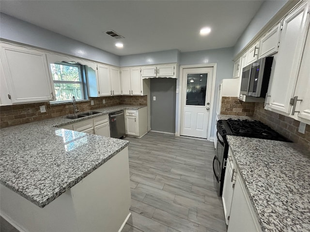 kitchen featuring white cabinets, light stone countertops, backsplash, and appliances with stainless steel finishes