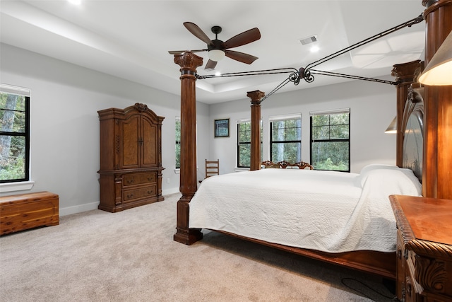 bedroom with ceiling fan, light carpet, and multiple windows