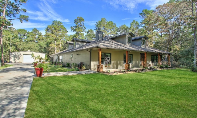 view of front of home with an outbuilding, a front lawn, covered porch, and a garage