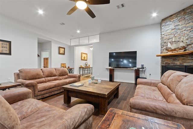 living room featuring hardwood / wood-style floors, ceiling fan, and a fireplace