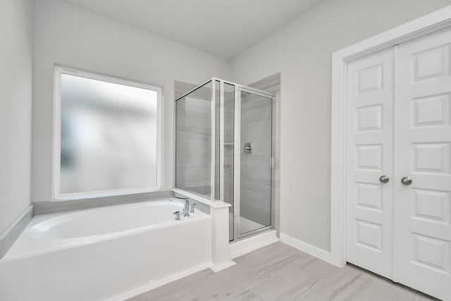 bathroom with plenty of natural light and separate shower and tub