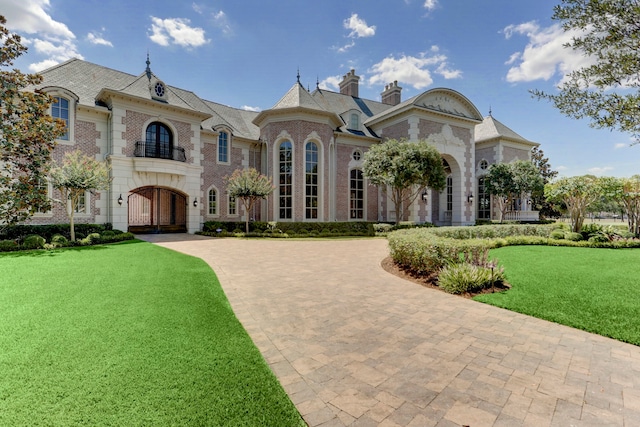 french country inspired facade featuring a front lawn