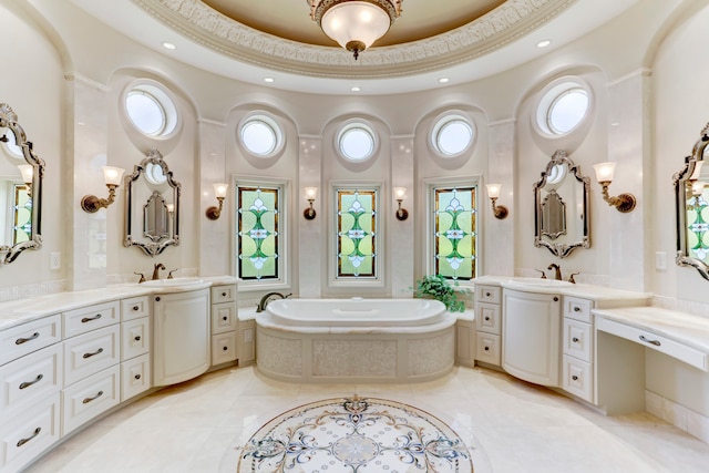 bathroom with vanity, plenty of natural light, and tiled tub