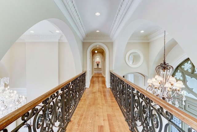 hallway featuring ornamental molding, a notable chandelier, and light hardwood / wood-style floors