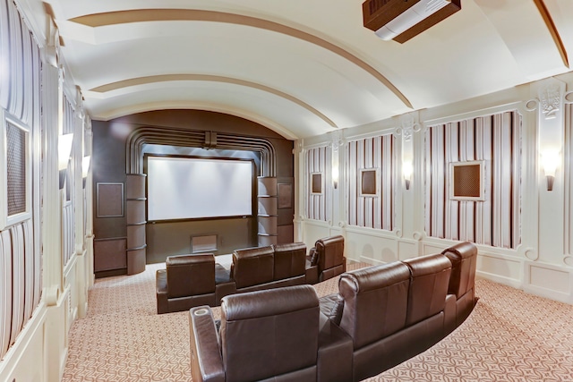 cinema featuring lofted ceiling, ornate columns, and light colored carpet