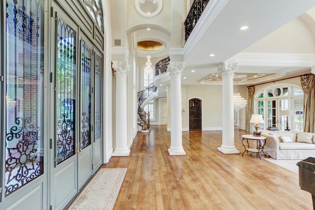 foyer entrance featuring french doors, light wood-type flooring, and decorative columns