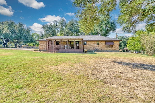 rear view of house featuring a yard and a wooden deck