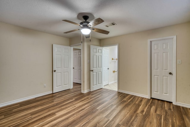 unfurnished bedroom featuring ceiling fan, dark hardwood / wood-style flooring, and a textured ceiling