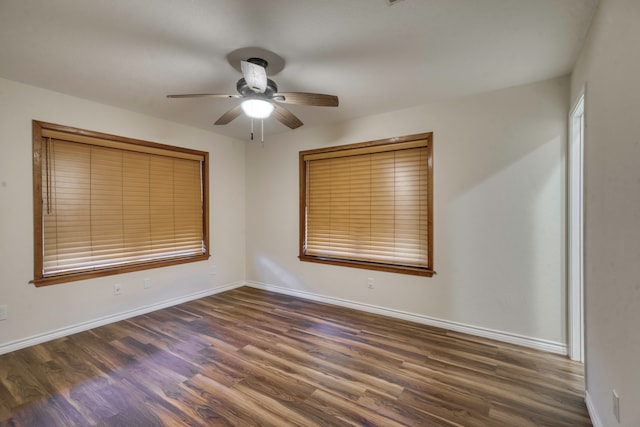 empty room with ceiling fan and dark hardwood / wood-style flooring