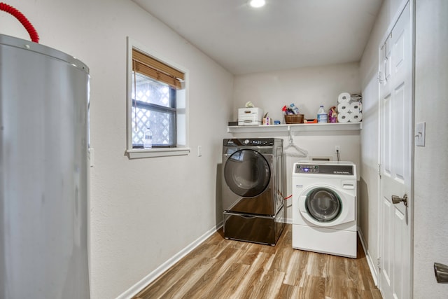 laundry area featuring washing machine and dryer and light wood-type flooring