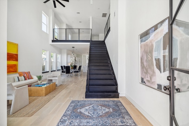 foyer featuring light hardwood / wood-style floors, a high ceiling, and ceiling fan