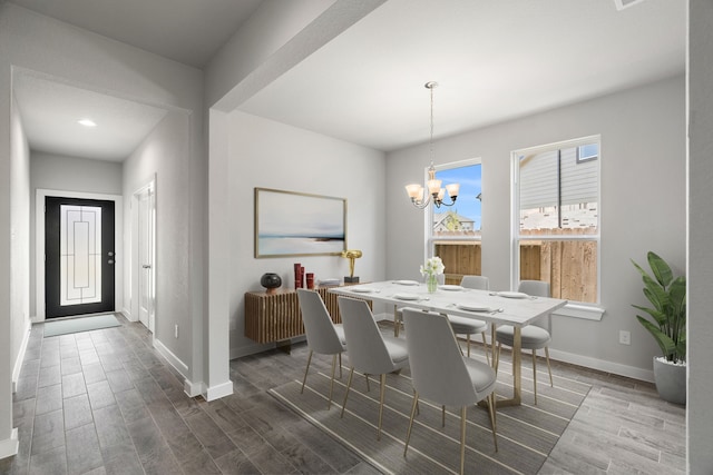 dining space featuring an inviting chandelier, wood finished floors, and baseboards