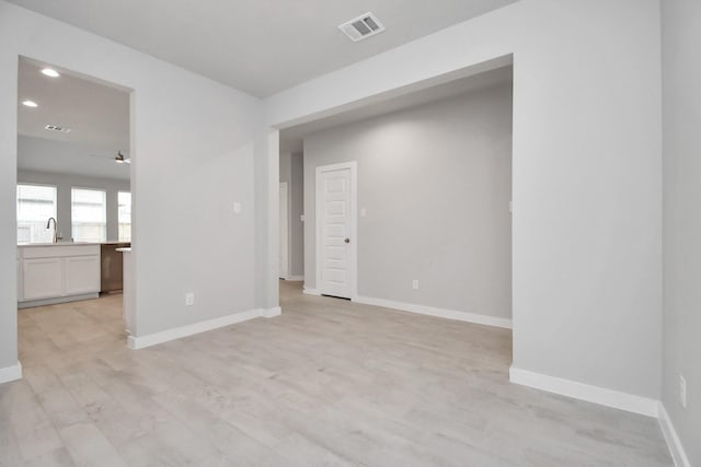 spare room with recessed lighting, light wood-style flooring, ceiling fan, baseboards, and visible vents