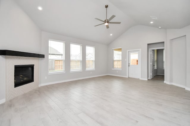 unfurnished living room featuring light wood-type flooring, a fireplace, and a healthy amount of sunlight