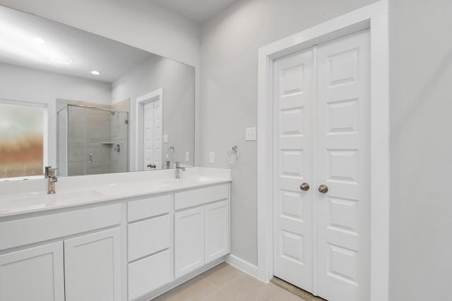 full bath featuring a shower stall, a sink, double vanity, a closet, and recessed lighting