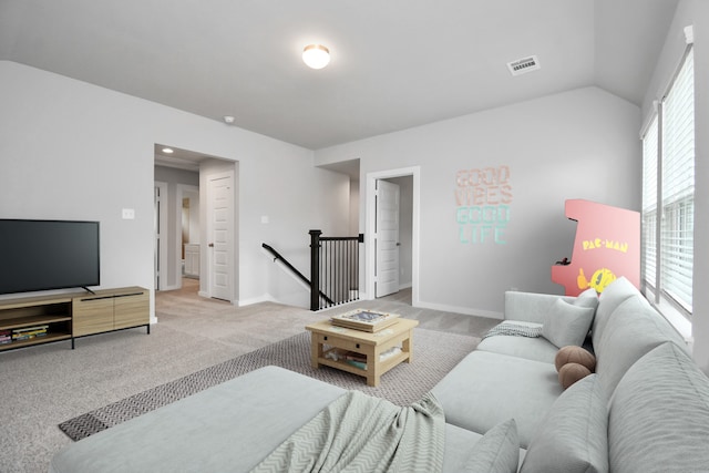 living area featuring visible vents, vaulted ceiling, and baseboards
