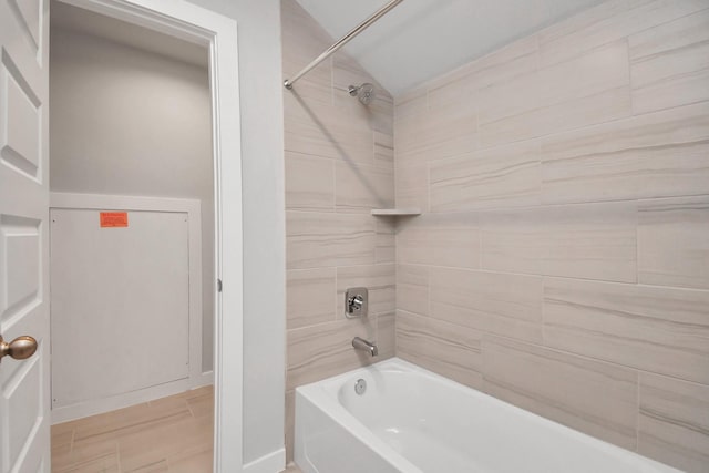 bathroom featuring tub / shower combination, wood finished floors, and baseboards