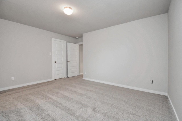 unfurnished room featuring carpet flooring and baseboards
