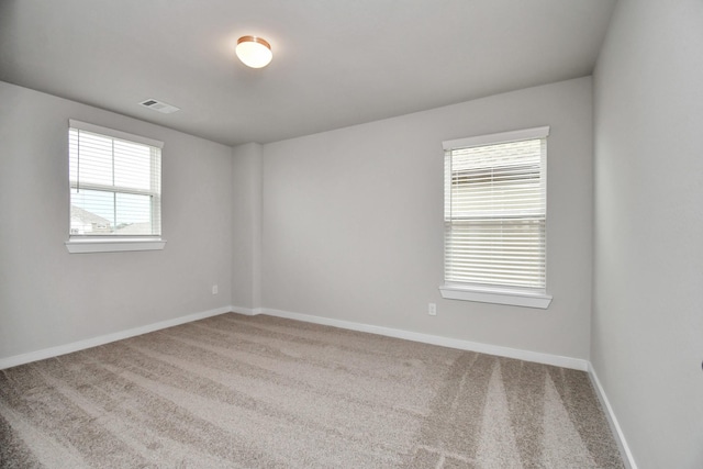 carpeted empty room with baseboards and visible vents