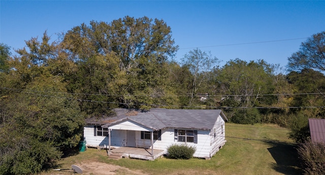 rear view of property featuring a lawn