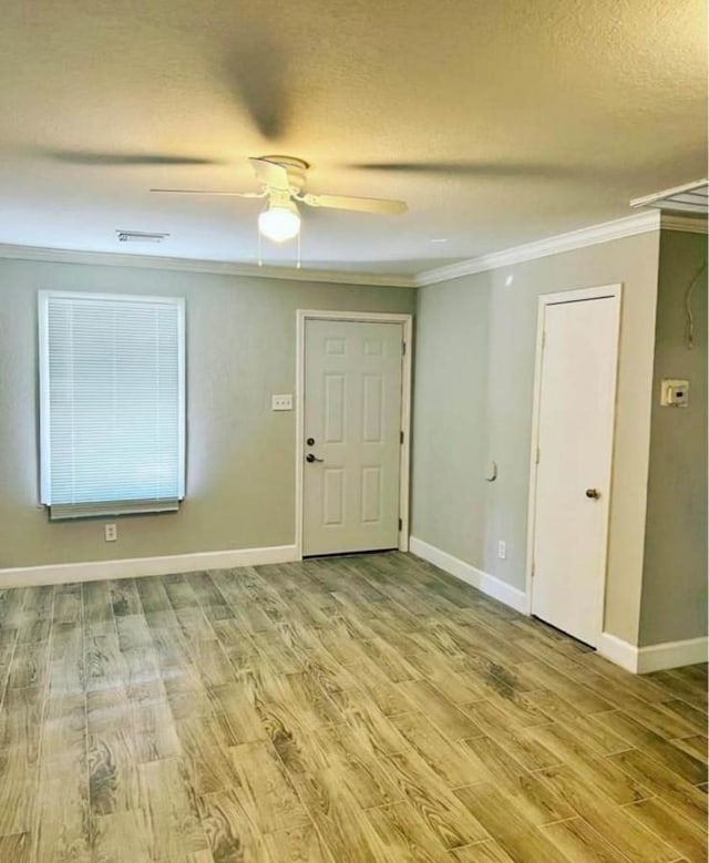 empty room featuring ornamental molding, hardwood / wood-style floors, and ceiling fan