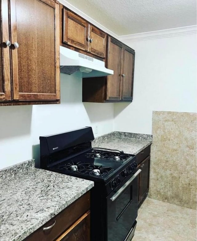 kitchen featuring crown molding, a textured ceiling, light stone counters, and black gas range oven