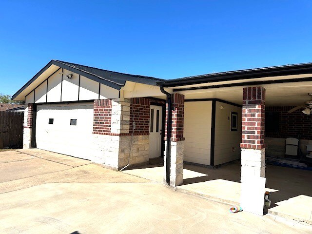 view of side of home with ceiling fan and a garage