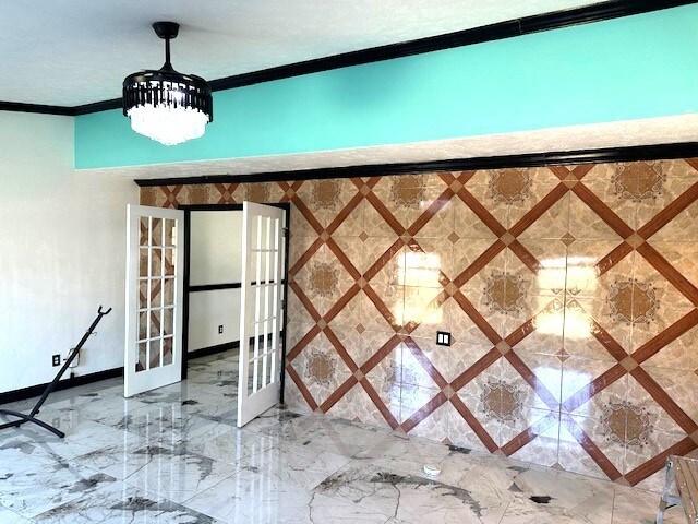 interior details featuring crown molding and french doors