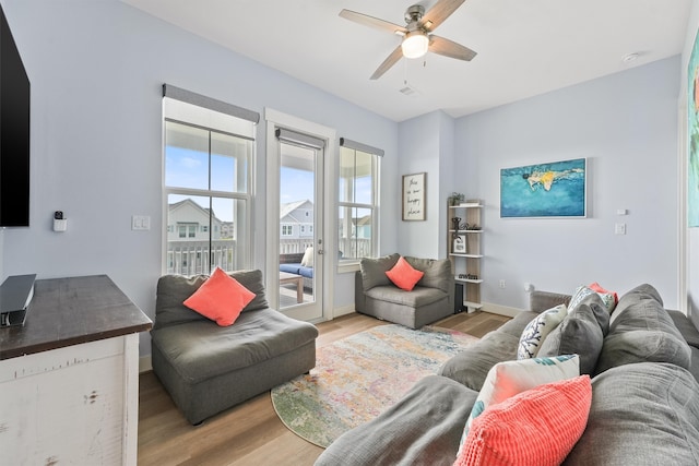 living room featuring light hardwood / wood-style flooring and ceiling fan