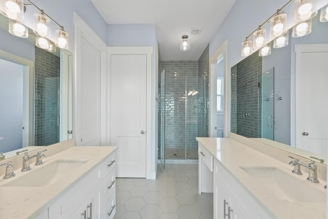 bathroom with vanity, a shower with shower door, and tile patterned floors