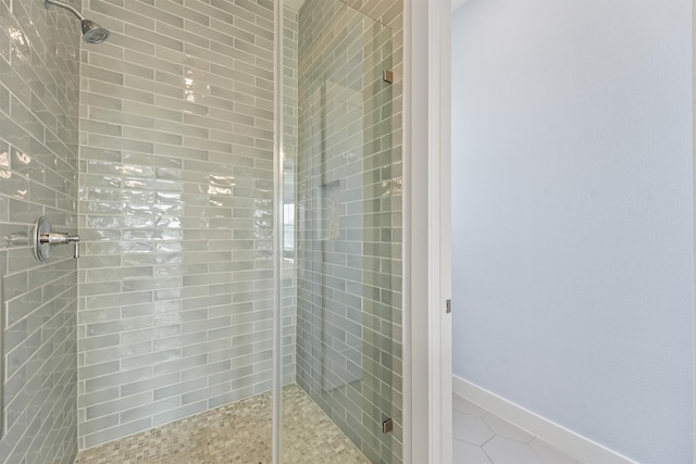 bathroom with an enclosed shower and tile patterned floors