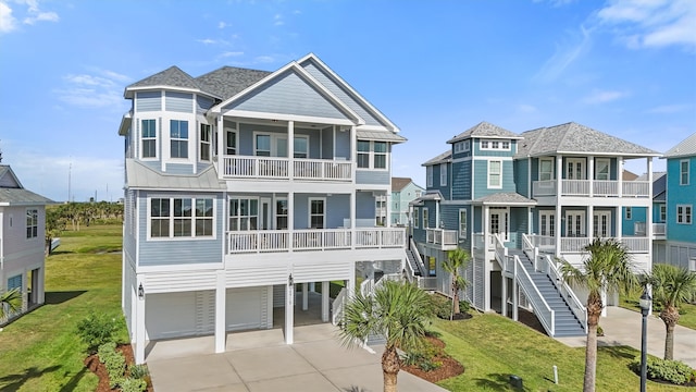 view of front of property featuring a carport, a front yard, a balcony, and a garage