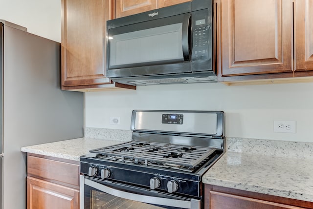 kitchen featuring light stone countertops and appliances with stainless steel finishes