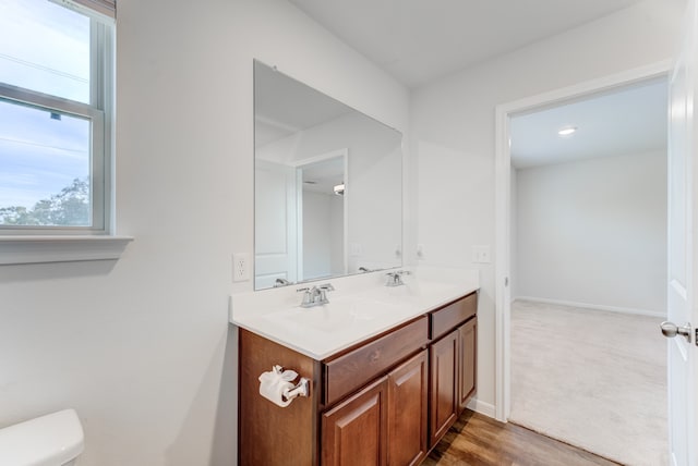 bathroom featuring vanity, hardwood / wood-style flooring, and toilet