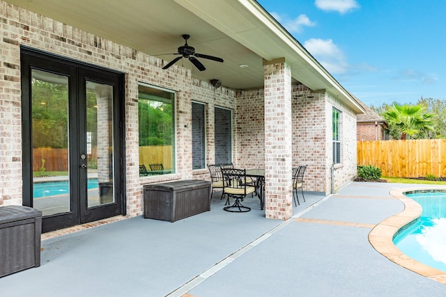 view of patio / terrace with french doors, a fenced in pool, and ceiling fan